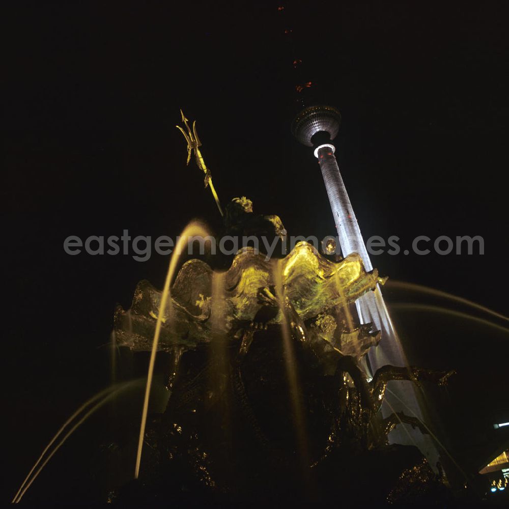 Berlin at night from above - Nachtaufnahme: Blick durch die Wasserfontänen des Neptunbrunnens auf den Fernsehturm am Jahrestag der DDR. Mit der Errichtung des Fernsehturms sowie der Umgestaltung seiner Umgebung Mitte der 6