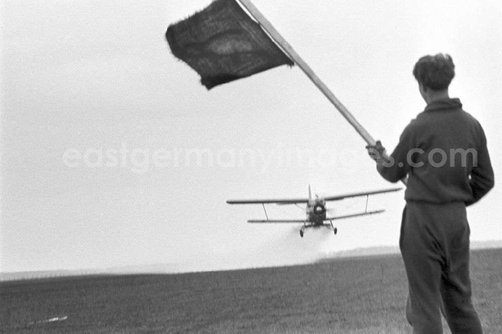 Möckern: Agricultural aircraft, type Antonov AN-2S of the Agrarflug operation of the state airline INTERFLUG in use on a field of an LPG - agricultural production cooperative for a spraying flight for fertilization and pest control in Moeckern, Saxony-Anhalt in the territory of the former GDR, German Democratic Republic