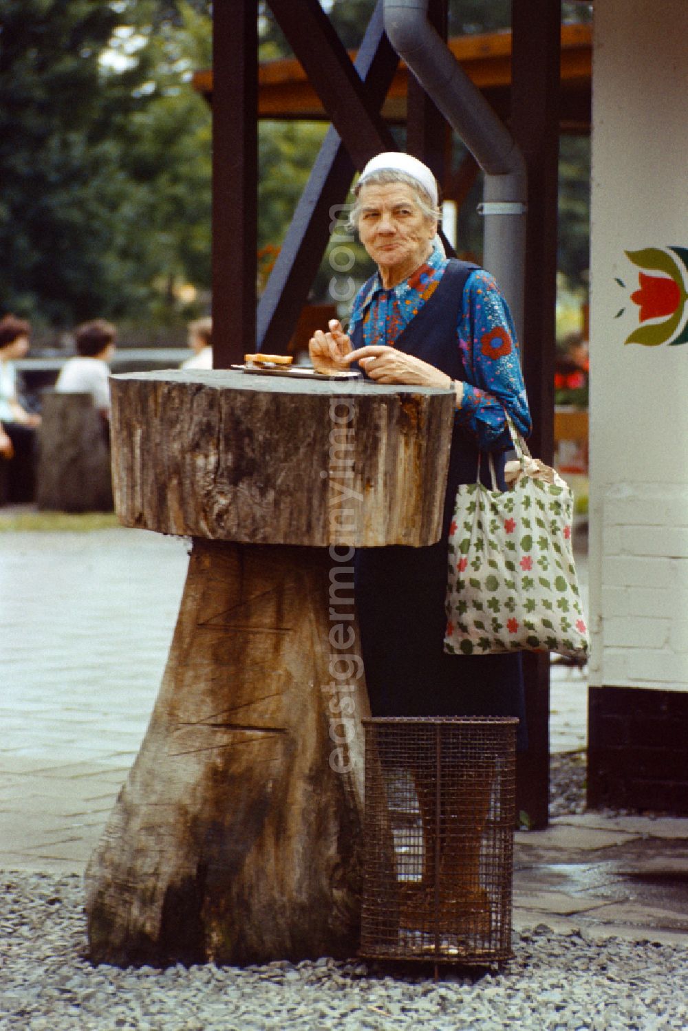 GDR picture archive: Berlin - Old woman eating a currywurst in East Berlin on the territory of the former GDR, German Democratic Republic