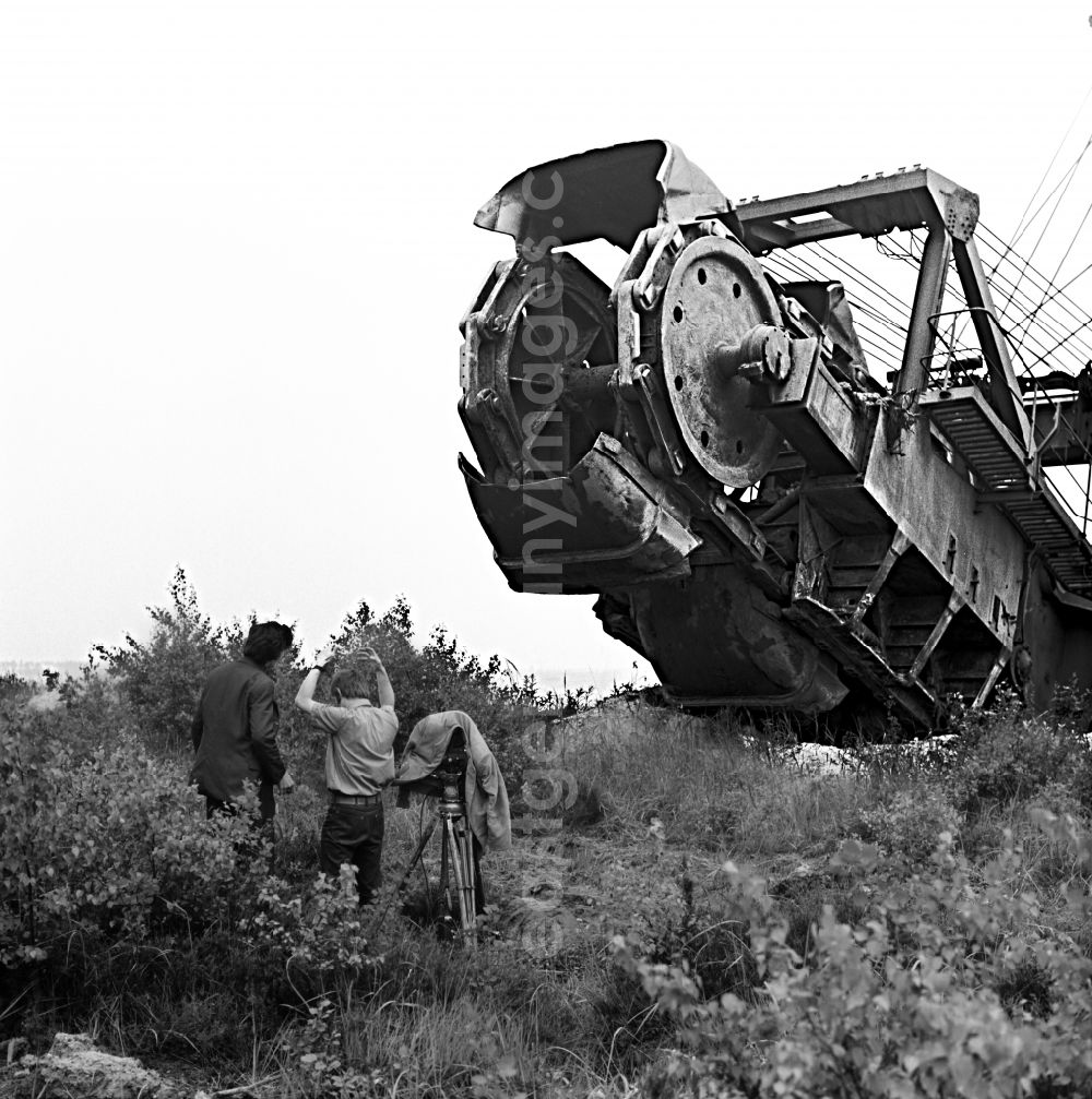 GDR photo archive: Senftenberg - Excavator on the site of the open-cast mine for the extraction of brown coal with rotating cameraman for filming Struga - Pictures of a Landscape in Senftenberg, Brandenburg in the area of the former GDR, German Democratic Republic