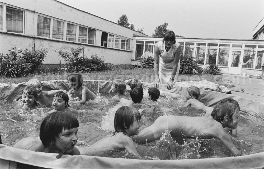 GDR picture archive: Berlin - Play and fun with small children supervised by educators in a kindergarten splashing around in a water basin on the street Rosenfelder Ring in the district of Lichtenberg in Berlin East Berlin in the area of the former GDR, German Democratic Republic