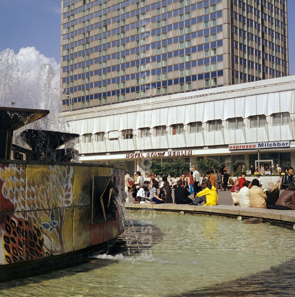 GDR photo archive: Berlin - Popular water feature - fountain Fountain of Friendship between Peoples on Alexanderplatz with a view of the Hotel Stadt Berlin in the Mitte district of Berlin East Berlin on the territory of the former GDR, German Democratic Republic