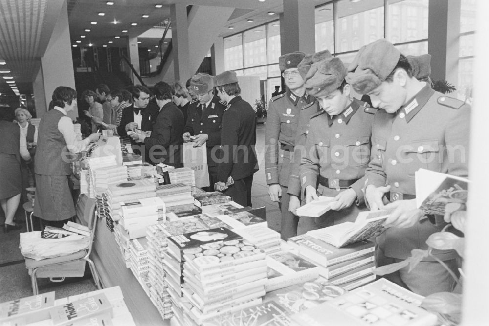 GDR photo archive: Dresden - Soldiers, non-commissioned officers and officers buying books as members of the NVA National People's Army at a sales stand of the MHO Military Trade Organization at the delegate conference in the Kulturpalast in the Altstadt district of Dresden, Saxony in the territory of the former GDR, German Democratic Republic