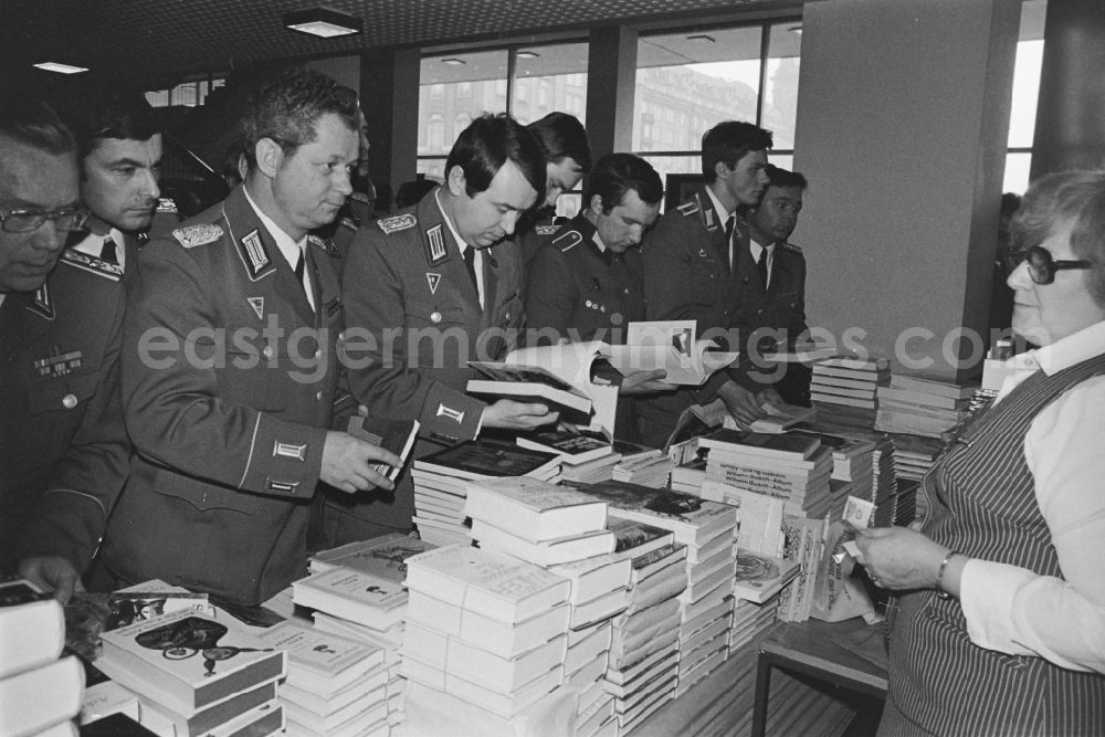 GDR photo archive: Dresden - Soldiers, non-commissioned officers and officers buying books as members of the NVA National People's Army at a sales stand of the MHO Military Trade Organization at the delegate conference in the Kulturpalast in the Altstadt district of Dresden, Saxony in the territory of the former GDR, German Democratic Republic