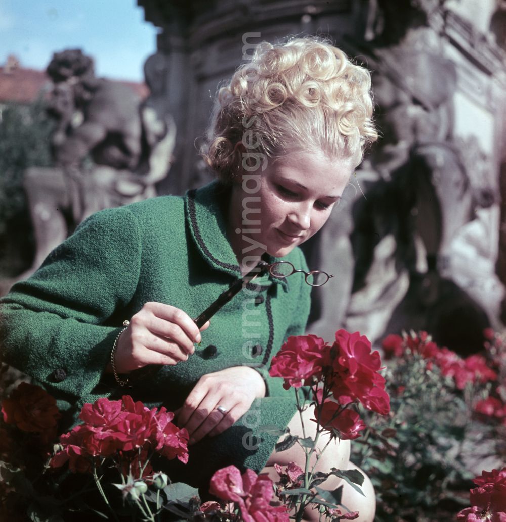 Dresden: Young woman presents current womens fashion collection with historical binoculars in her hand in Dresden, Saxony in the area of the former GDR, German Democratic Republic