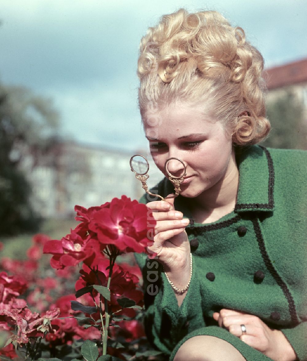 GDR image archive: Dresden - Young woman presents current womens fashion collection with historical binoculars in her hand in Dresden, Saxony in the area of the former GDR, German Democratic Republic