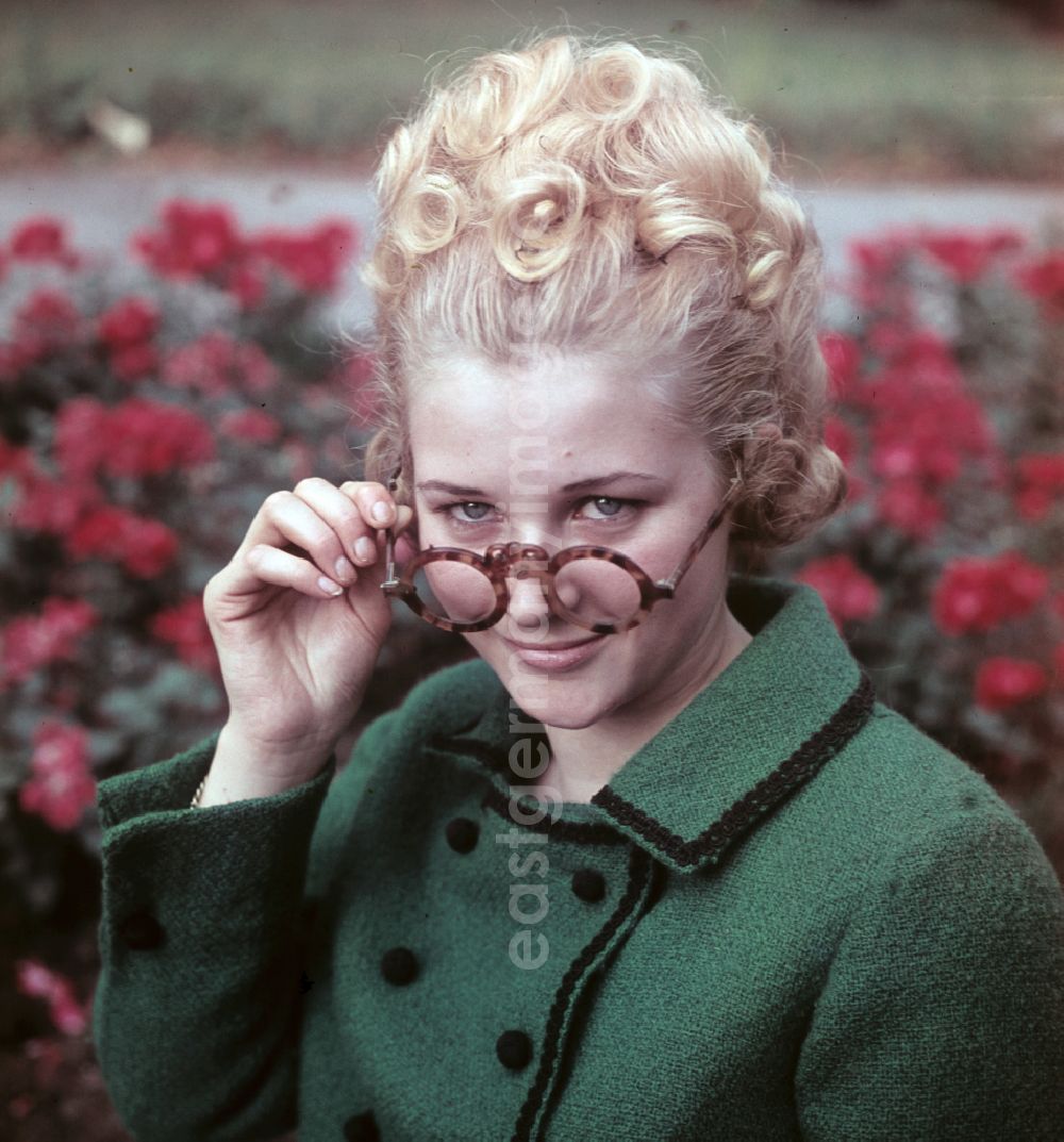 GDR photo archive: Dresden - Young woman presents current womens fashion collection with historical binoculars in her hand in Dresden, Saxony in the area of the former GDR, German Democratic Republic