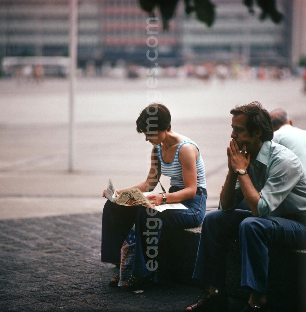 GDR photo archive: Berlin - Eine Frau liest auf dem Alexanderplatz in Berlin-Mitte ihre Zeitung.