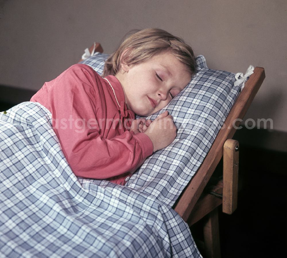 GDR photo archive: Berlin - A little girl taking a nap in the kindergarten on Michael-Brueckner-Strasse in the Schoeneweide district of Berlin in the territory of the former GDR, German Democratic Republic