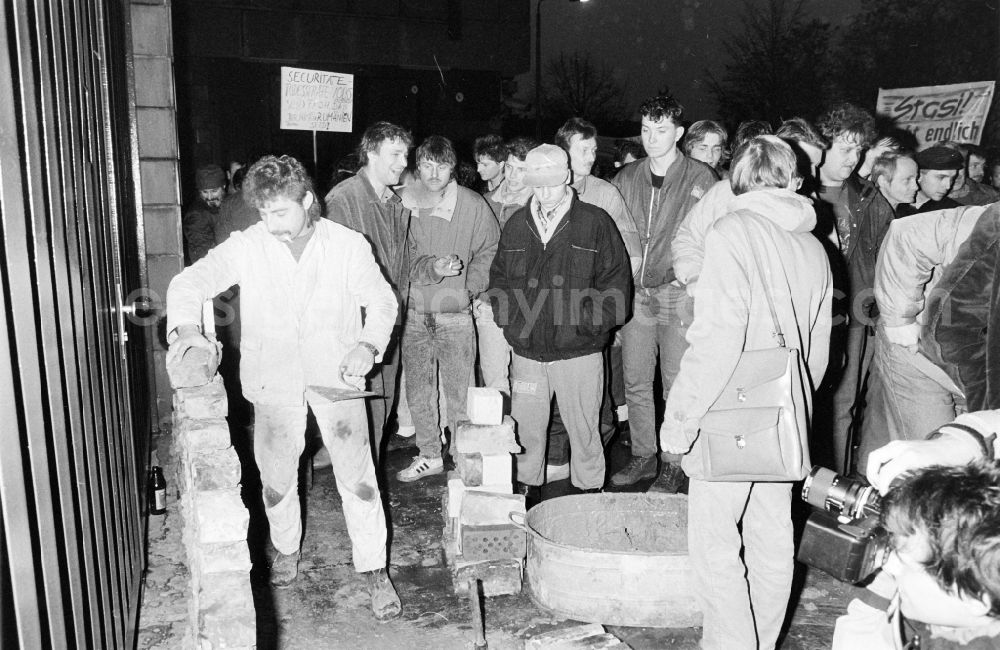 GDR photo archive: Berlin - Demonstrators and protesters during the storming and occupation the headquarters of the MfS Ministry for State Security on street Ruschestrasse - Normannenstrasse in the district Lichtenberg in Berlin Eastberlin on the territory of the former GDR, German Democratic Republic