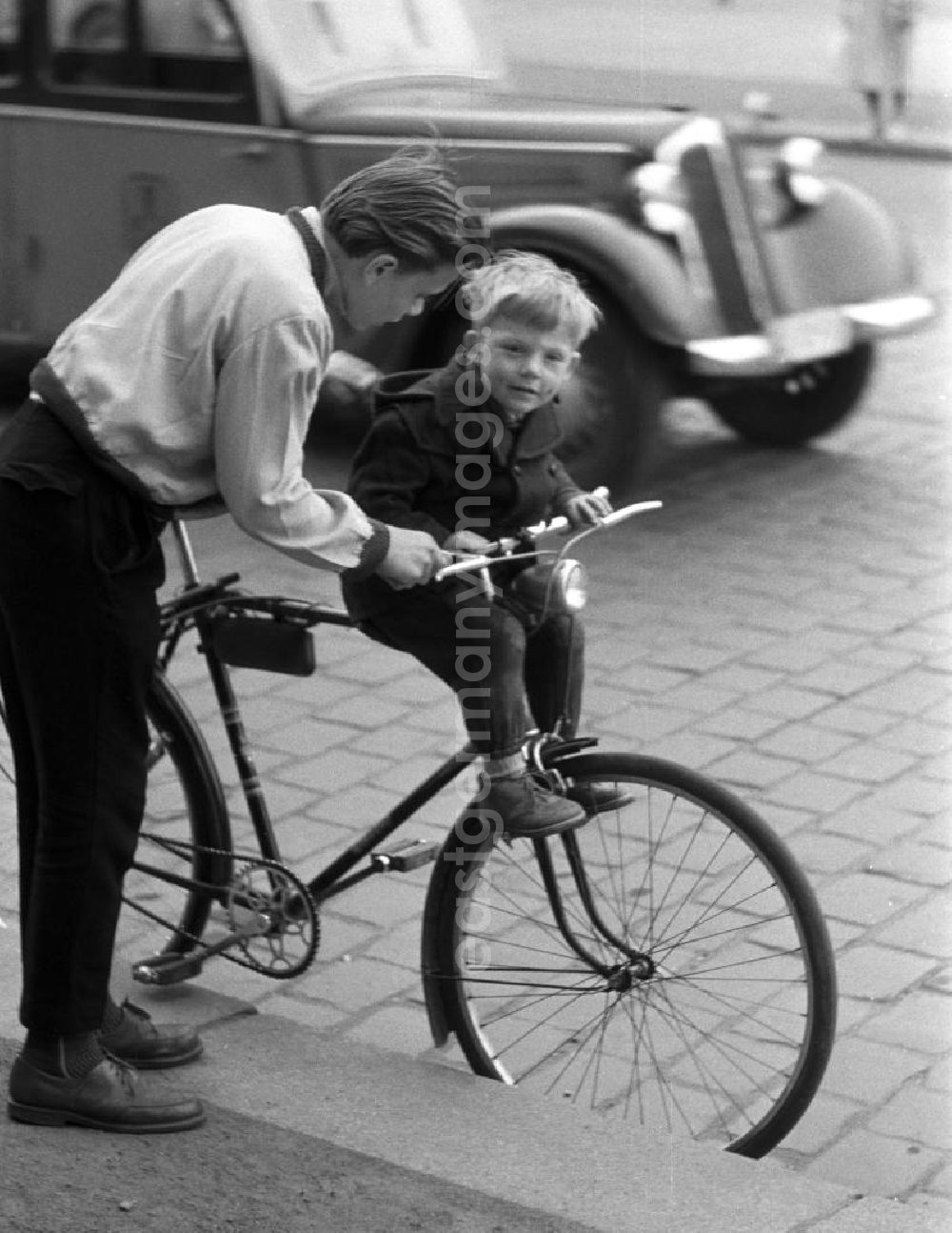 GDR picture archive: - Ein Junge nimmt seinen kleinen Bruder auf dem Fahrrad mit. Die Kindersitze waren auf der Fahrradstange befestigt, die Füße ruhten auf kleinen, an der Radgabel befestigten Trittstegen.