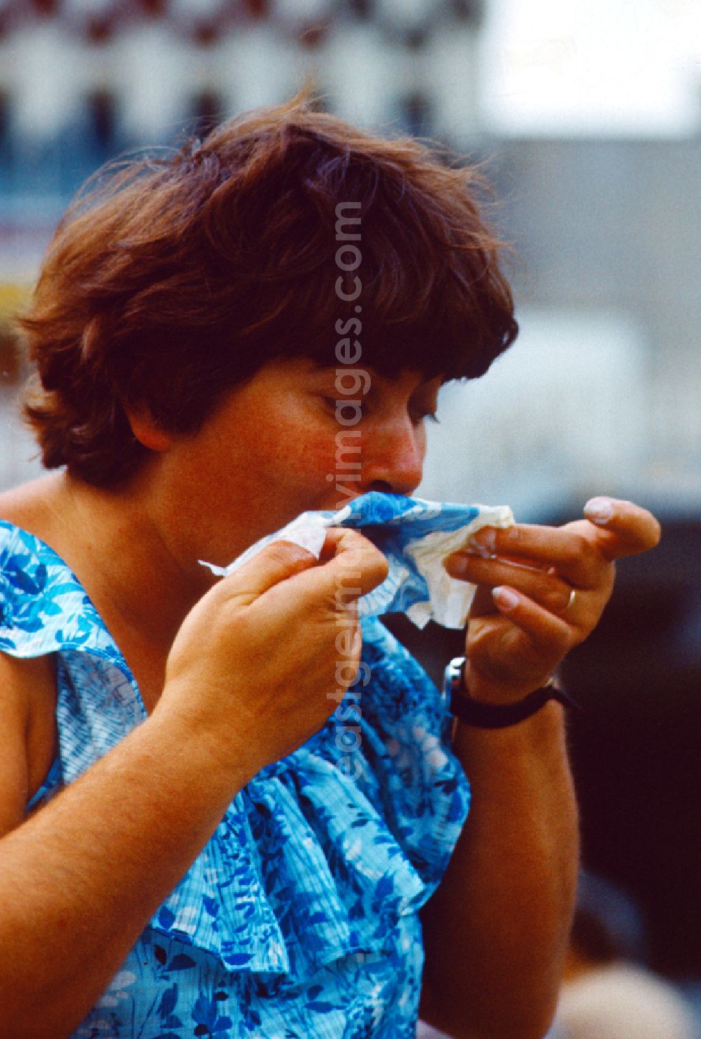 GDR photo archive: Berlin - Woman cleaning her mouth with a napkin in East Berlin on the territory of the former GDR, German Democratic Republic