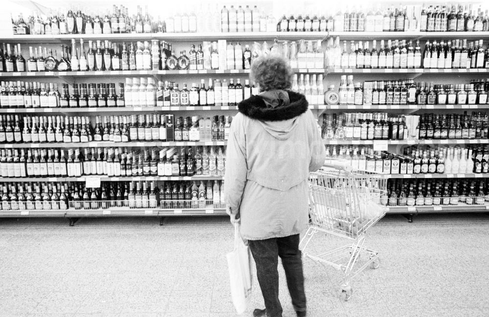 Berlin: Woman at the liquor shelf in a supermarket in Berlin