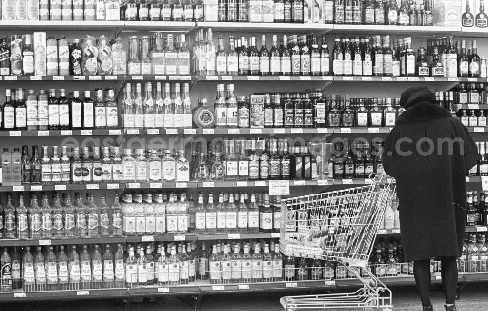 GDR image archive: Berlin - Woman at the liquor shelf in a supermarket in Berlin