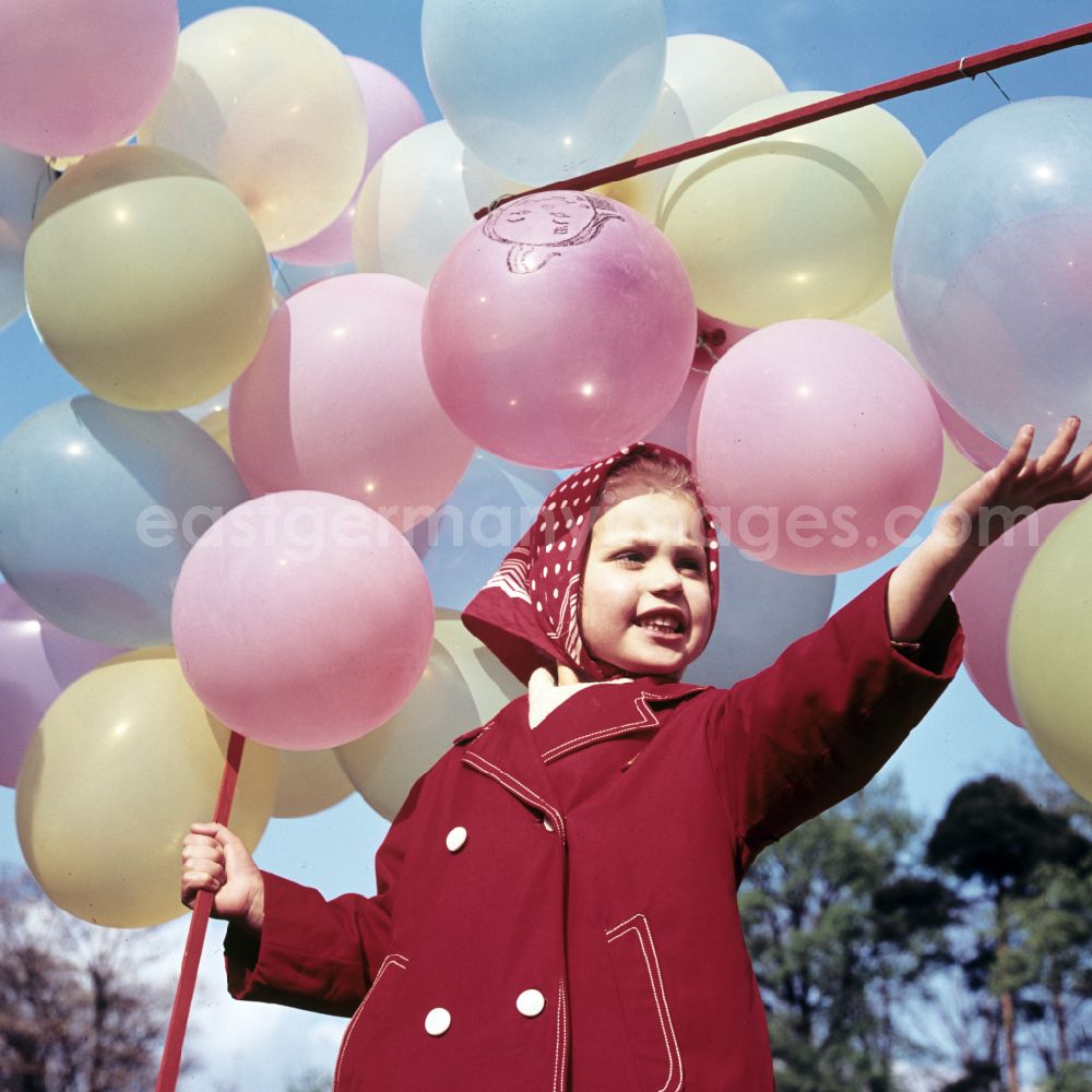 GDR picture archive: Coswig - Girl with balloons in a stroller in Coswig, Saxony in the territory of the former GDR, German Democratic Republic