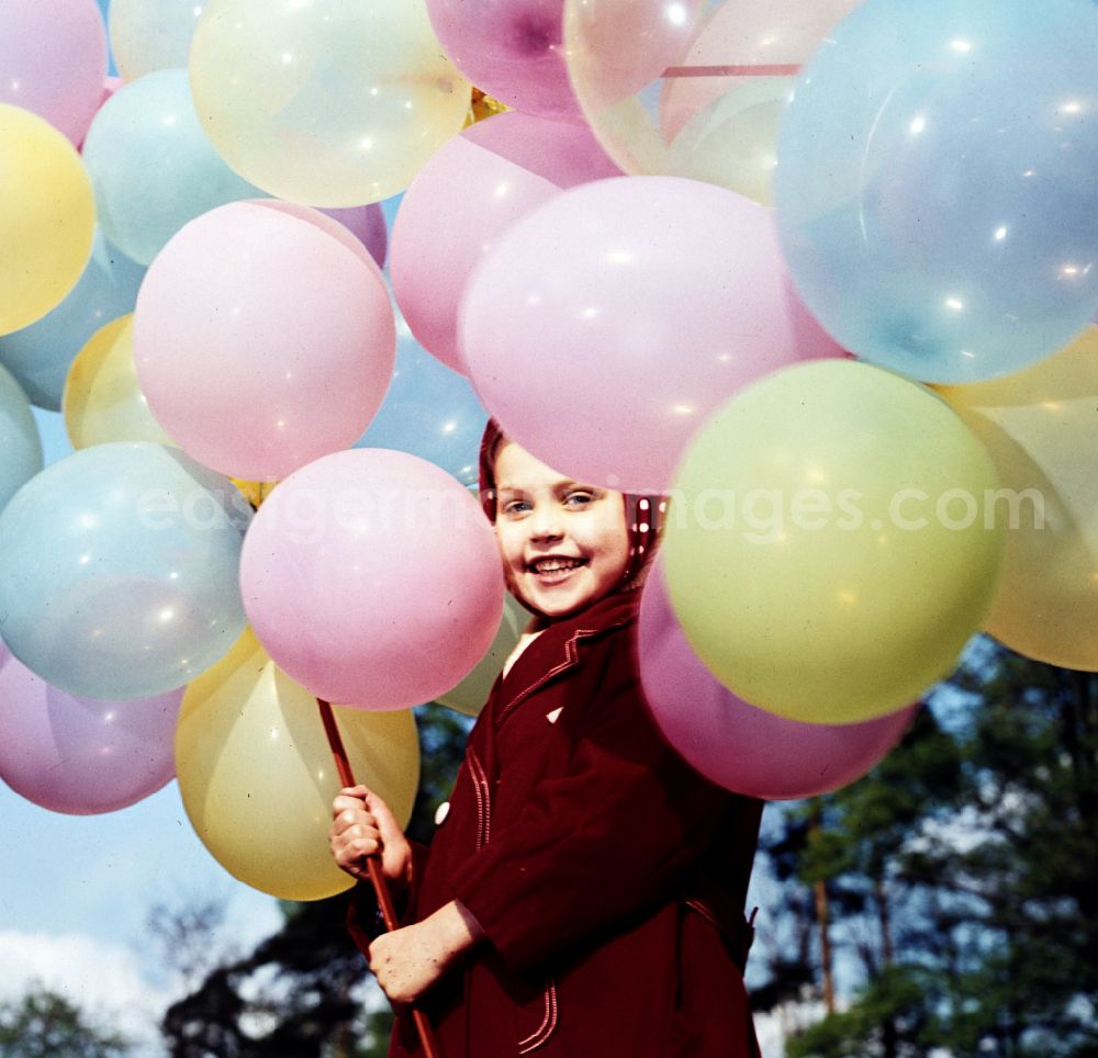 GDR image archive: Coswig - Girl with balloons in a stroller in Coswig, Saxony in the territory of the former GDR, German Democratic Republic