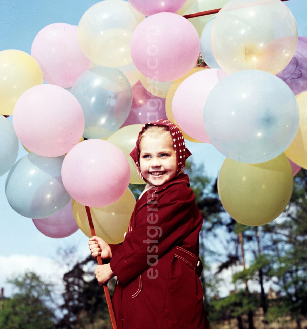 GDR picture archive: Coswig - Girl with balloons in a stroller in Coswig, Saxony in the territory of the former GDR, German Democratic Republic