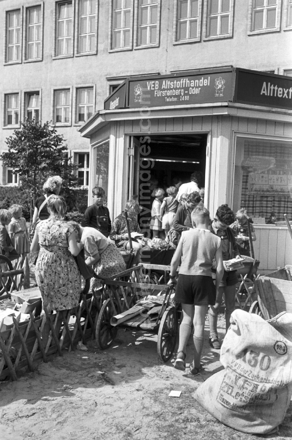 GDR image archive: Eisenhüttenstadt (Stalinstadt) - Children handing in waste materials, waste paper, bottles and gases as secondary raw materials for collection at the state-run SERO collection points in Fuerstenberg-Oder (Eisenhuettenstadt), Brandenburg in the area of the former GDR, German Democratic Republic