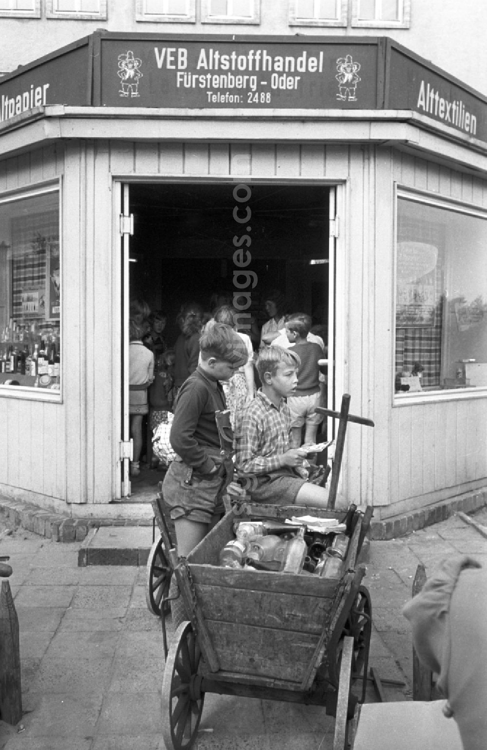 GDR photo archive: Eisenhüttenstadt (Stalinstadt) - Children handing in waste materials, waste paper, bottles and gases as secondary raw materials for collection at the state-run SERO collection points in Fuerstenberg-Oder (Eisenhuettenstadt), Brandenburg in the area of the former GDR, German Democratic Republic