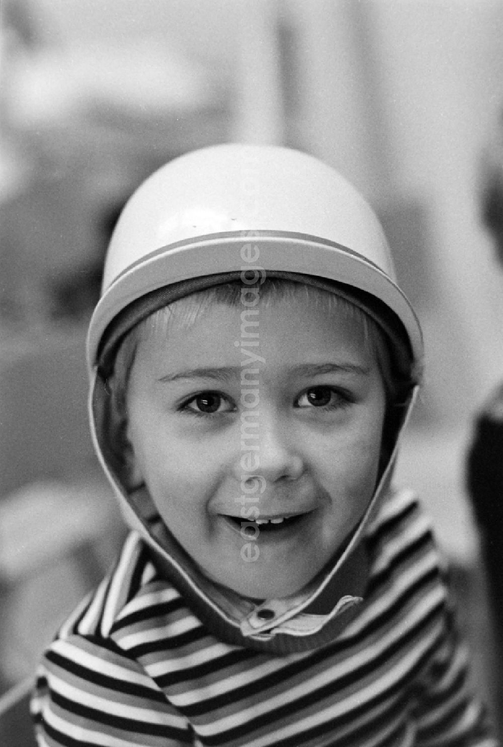 GDR picture archive: Hennigsdorf - Child wearing a motorcycle helmet in the children's combination / in the kindergarten Puenktchen in Hennigsdorf on the territory of the former GDR, German Democratic Republic