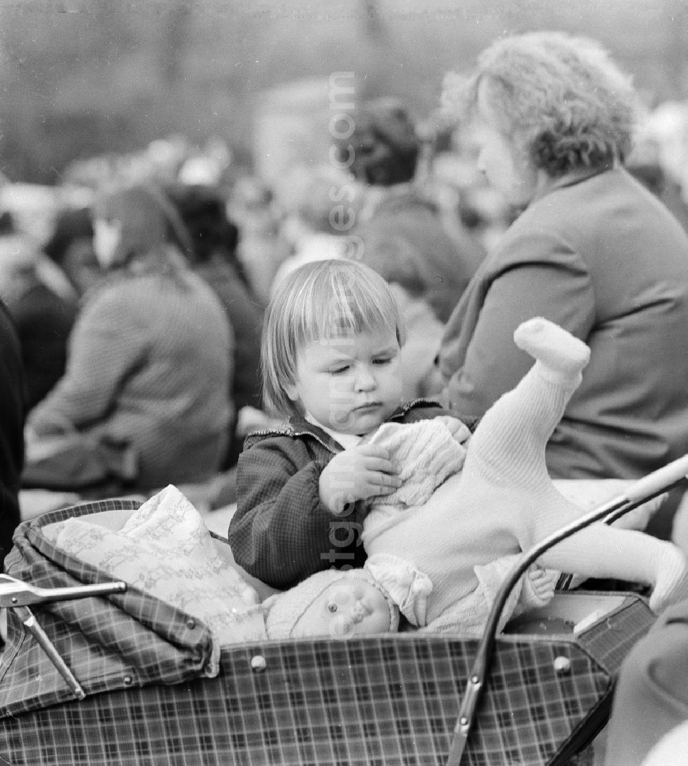 GDR picture archive: Berlin - A little girl plays with her doll and the doll carriage in Berlin, the former capital of the GDR, German democratic republic