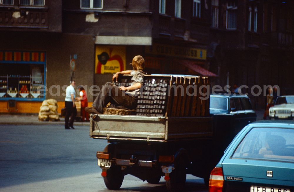 Berlin: Worker - coal carrier Coal carrier on the loading area of a small truck with baskets full of coal in the Mitte district of East Berlin in the territory of the former GDR, German Democratic Republic