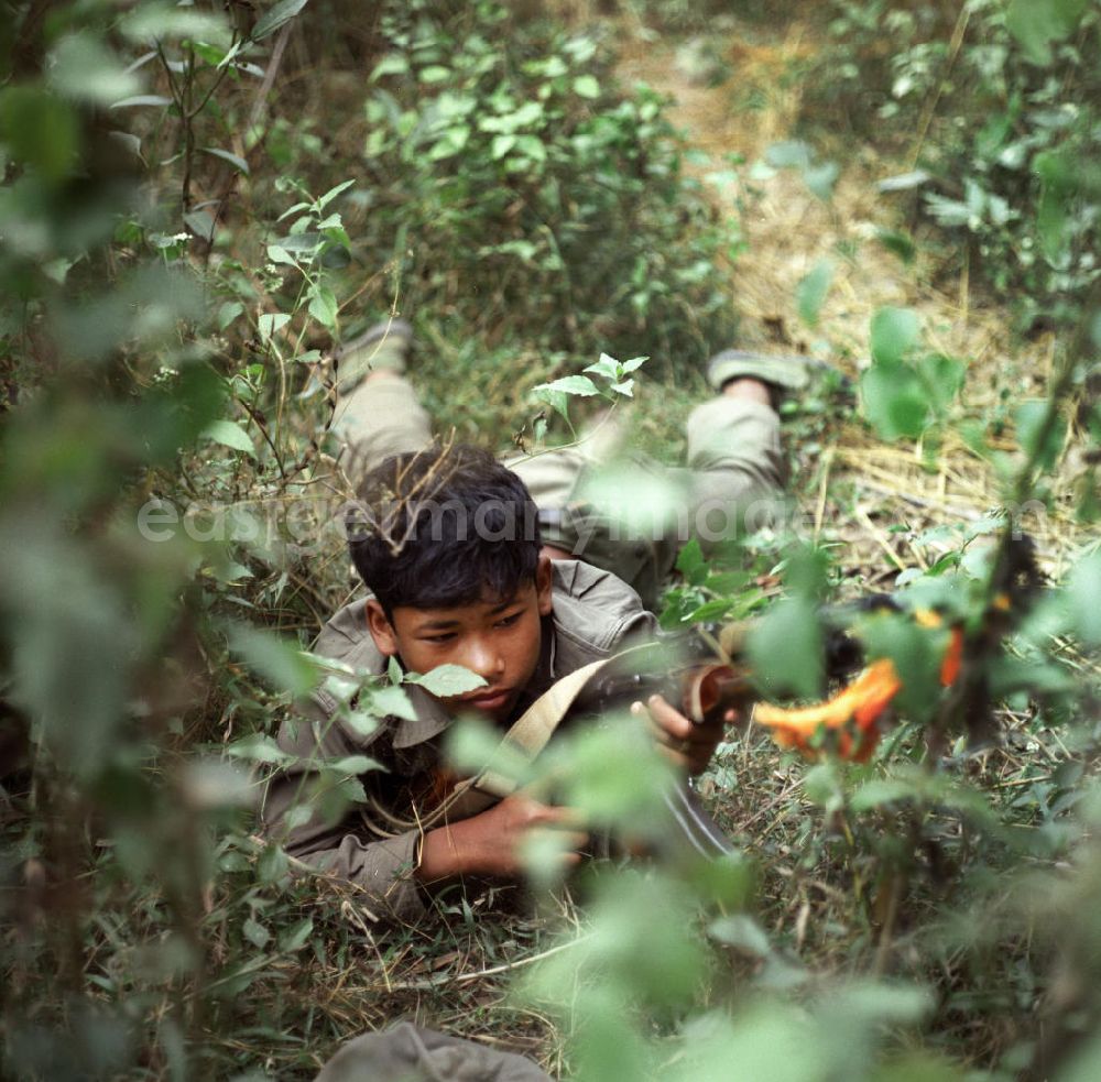GDR picture archive: Nam Ngum - Junger Soldat der laotischen Armee in der Demokratischen Volksrepublik Laos bei einer Übung. Erst zwei Jahre zuvor, am 2. Dezember 1975, war durch die kommunistisch geprägten Kräfte die Volksrepublik Laos ausgerufen worden. Die politische und wirtschaftliche Situation blieb aber auch in den Folgejahren unsicher und instabil.
