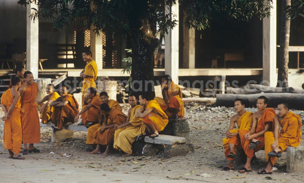 GDR picture archive: Vientiane - Mönche in den charakteristischen safrangelben Gewändern in einem buddhistischen Tempel in Vientiane, der Hauptstadt der Demokratischen Volksrepublik Laos. Bis zur Ausrufung der Volksrepublik Laos am 2. Dezember 1975 bestimmte der Theravada-Buddhismus die kulturelle Entwicklung im Land. Nachdem die anfängliche Unterdrückung der traditionellen buddhistischen Bräuche durch die neuen kommunistischen Machthaber mißlang, fand Laos in den folgenden Jahrzehnten einen eigenen Weg der Koexistenz von Buddhismus und Sozialismus.