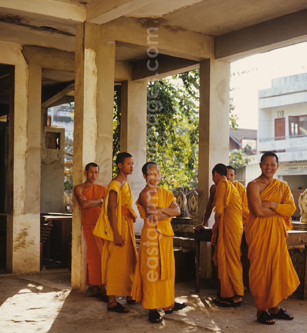 GDR image archive: Vientiane - Mönche in den charakteristischen safrangelben Gewändern in einem buddhistischen Tempel in Vientiane, der Hauptstadt der Demokratischen Volksrepublik Laos. Bis zur Ausrufung der Volksrepublik Laos am 2. Dezember 1975 bestimmte der Theravada-Buddhismus die kulturelle Entwicklung im Land. Nachdem die anfängliche Unterdrückung der traditionellen buddhistischen Bräuche durch die neuen kommunistischen Machthaber mißlang, fand Laos in den folgenden Jahrzehnten einen eigenen Weg der Koexistenz von Buddhismus und Sozialismus.