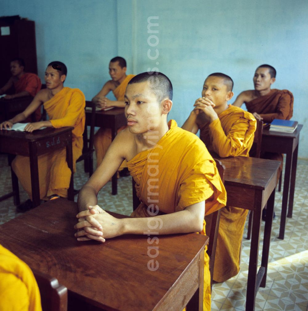 GDR picture archive: Vientiane - Mönche in den charakteristischen safrangelben Gewändern lernen in der Schule in einem buddhistischen Tempel in Vientiane, der Hauptstadt der Demokratischen Volksrepublik Laos. Bis zur Ausrufung der Volksrepublik Laos am 2. Dezember 1975 bestimmte der Theravada-Buddhismus die kulturelle Entwicklung im Land. Nachdem die anfängliche Unterdrückung der traditionellen buddhistischen Bräuche durch die neuen kommunistischen Machthaber mißlang, fand Laos in den folgenden Jahrzehnten einen eigenen Weg der Koexistenz von Buddhismus und Sozialismus.