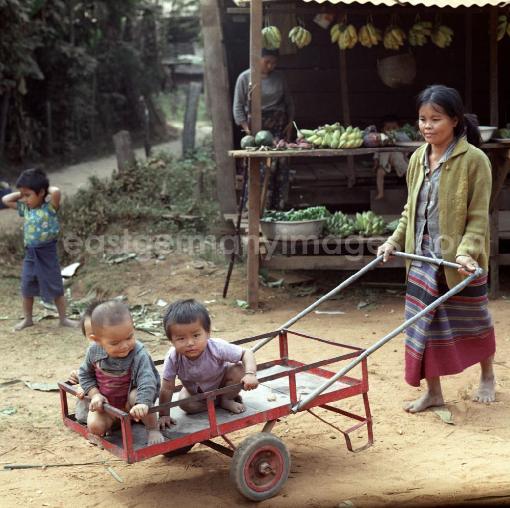 GDR photo archive: Vientiane - Frau mit Kindern in einem Dorf in der Demokratischen Volksrepublik Laos.
