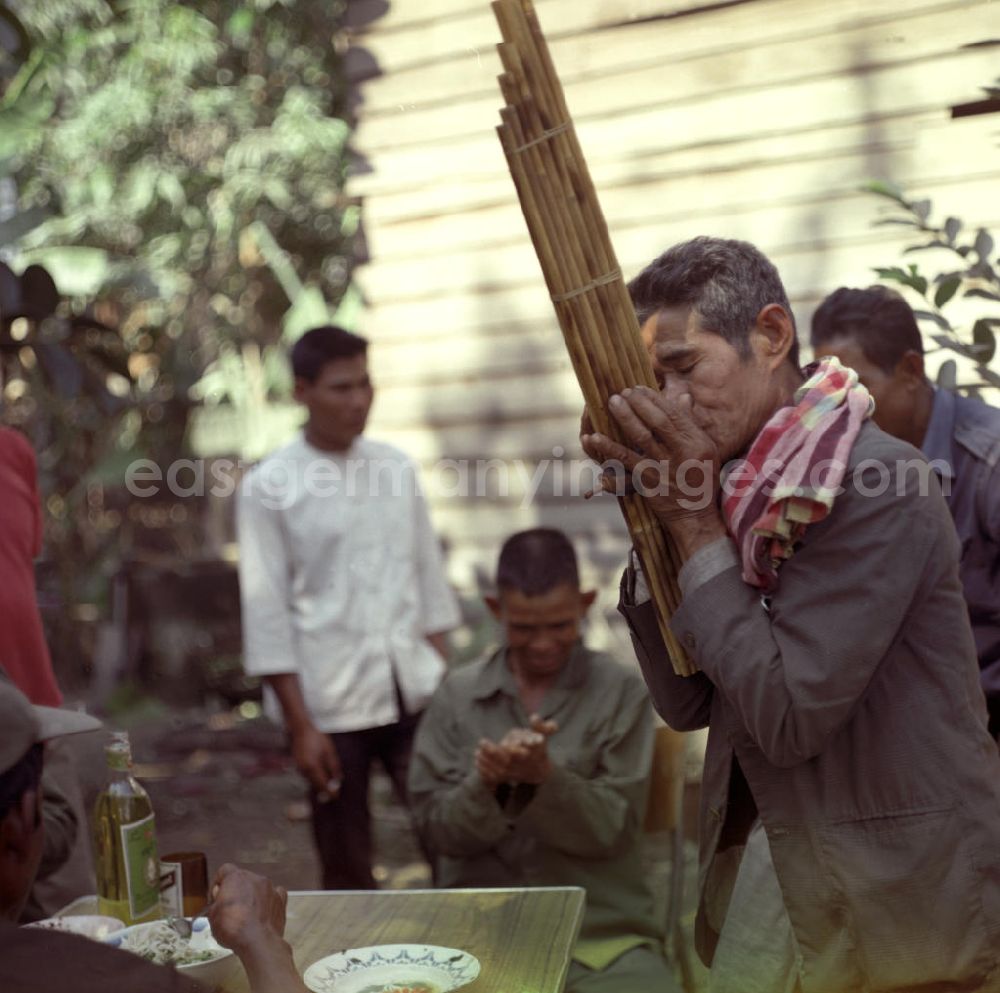 GDR photo archive: Vientiane - Ein Mann spielt auf einer Khaen zu einer Hochzeit in einem Dorf in der Demokratischen Volksrepublik Laos.