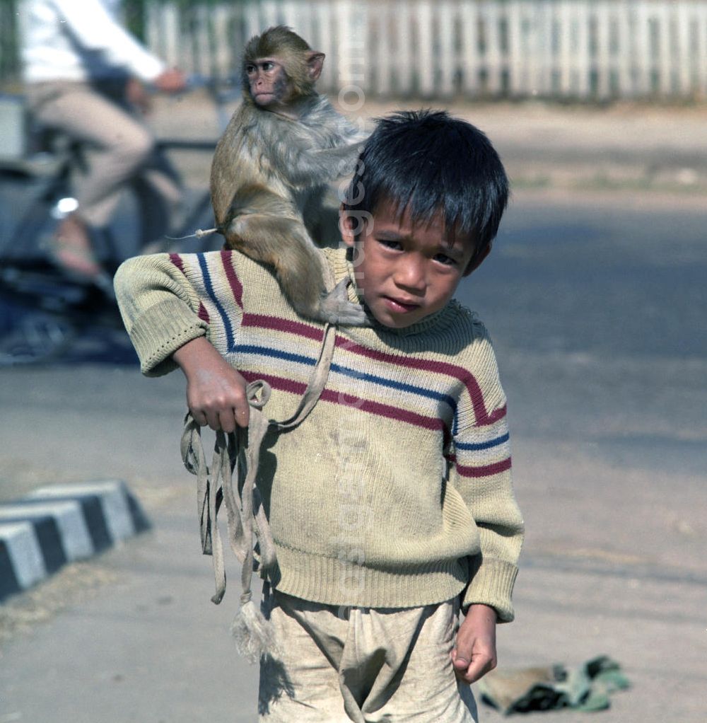 Vientiane: Ein Junge mit einem Affen auf seiner Schulter steht auf einer Straße in Vientiane, der Hauptstadt der Demokratischen Volksrepublik Laos.