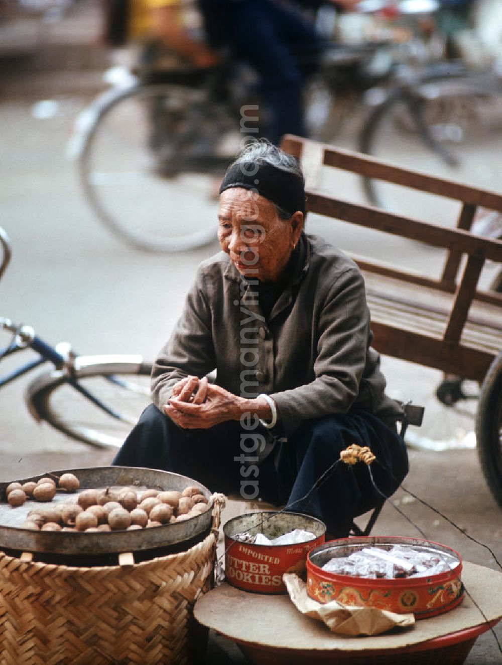 GDR photo archive: Vientiane - Eine alte Frau verkauft Lebensmittel am Rande des Marktes in Vientiane in der Demokratischen Volksrepublik Laos.