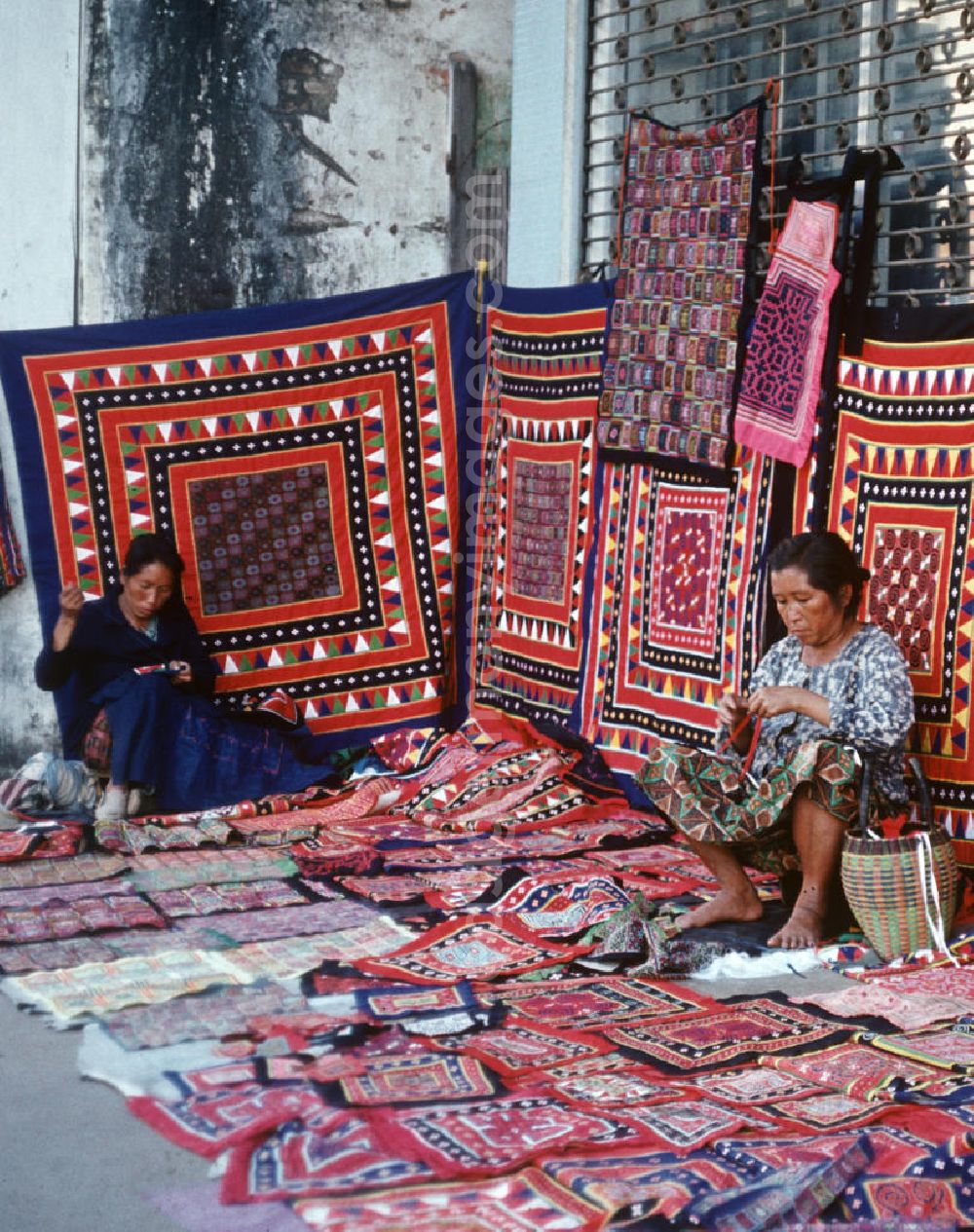 GDR photo archive: Vientiane - Frauen aus dem Volksstamm der Meo, auch Hmong genannt, verkaufen selbstgenähte Decken in Vientiane, der Hauptstadt der Demokratischen Volksrepublik Laos. Die Hmong gehörten zu einer infolge des Vietnam-Krieges verfolgten und zurückgezogen lebenden Minderheit in Laos.