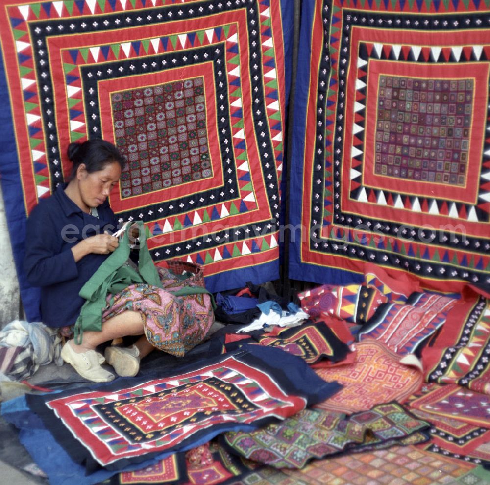 Vientiane: Eine Frau aus dem Volksstamm der Meo, auch Hmong genannt, verkauft selbstgenähte Decken in Vientiane, der Hauptstadt der Demokratischen Volksrepublik Laos. Die Hmong gehörten zu einer infolge des Vietnam-Krieges verfolgten und zurückgezogen lebenden Minderheit in Laos.