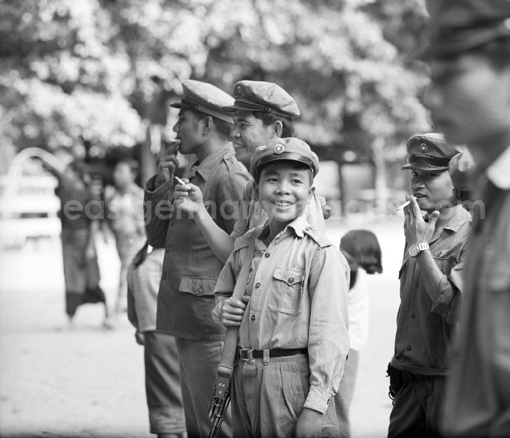 GDR picture archive: Vientiane - Männliche Milizionäre - unter ihnen noch ein Kind - in Uniform in Vientiane in der Demokratischen Volksrepublik Laos.