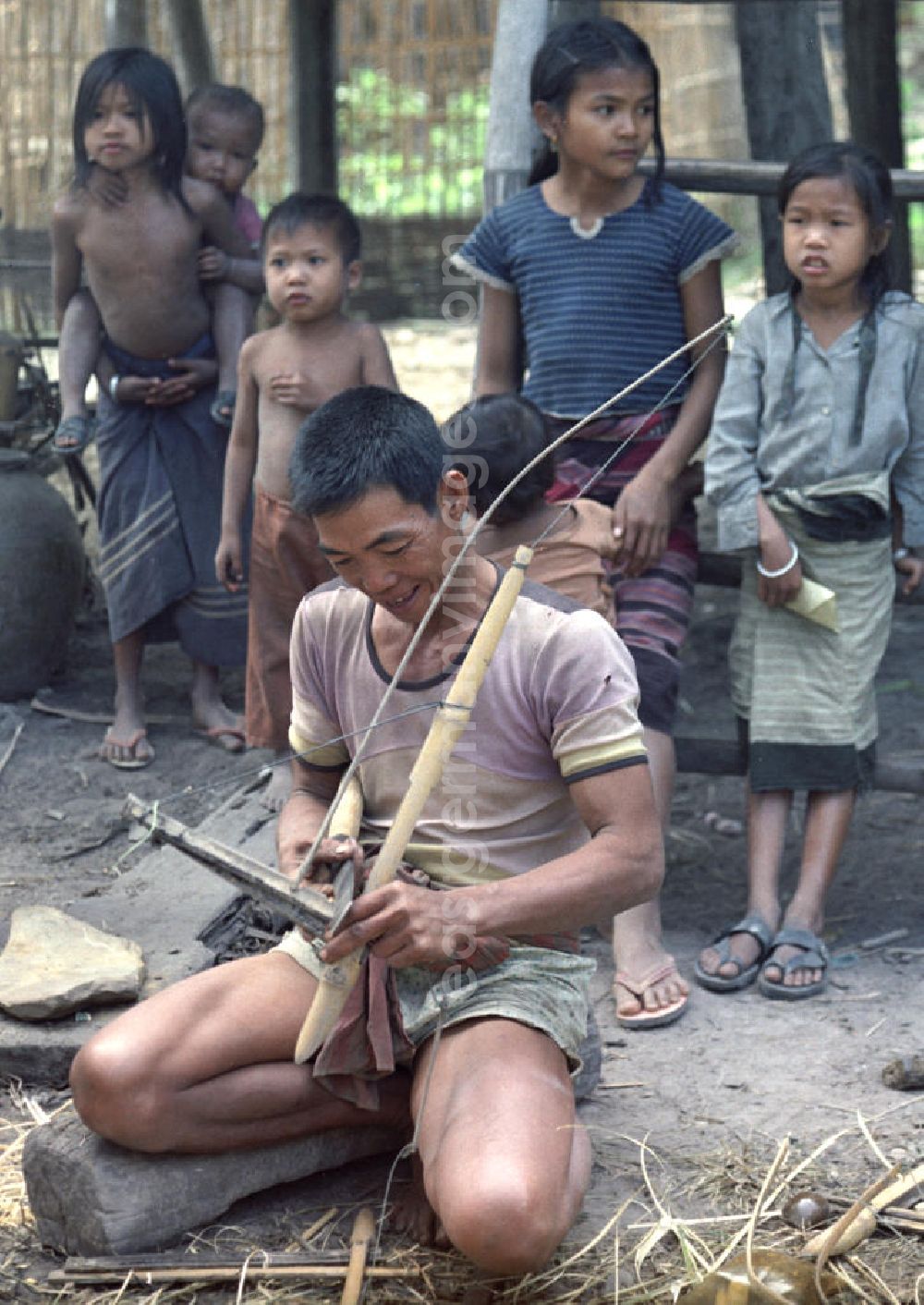 GDR picture archive: Vientiane - Ein Mann baut in einem Dorf in der Demokratischen Volksrepublik Laos Fallen für Ratten.