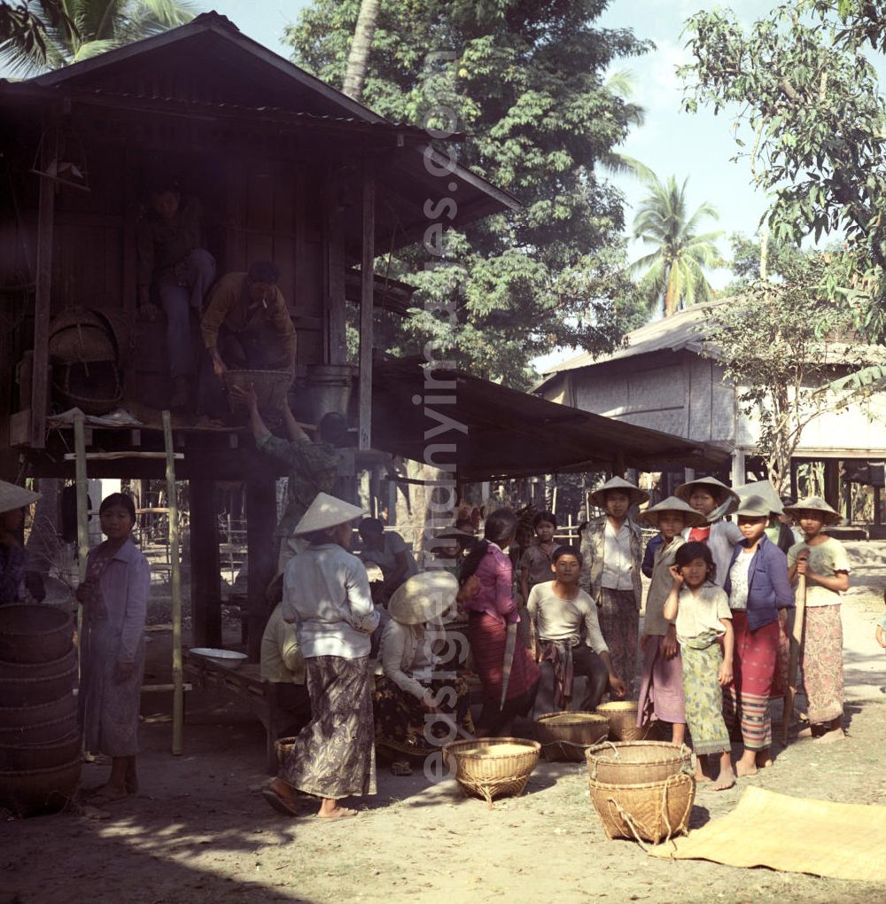 GDR image archive: Vientiane - Der geerntete Reis wird an einer Sammelstelle in einem Dorf in der Demokratischen Volksrepublik Laos zusammengetragen.