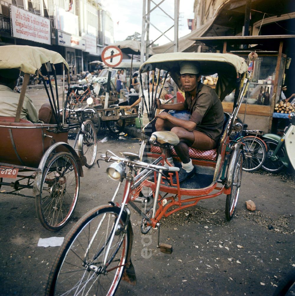 GDR picture archive: Vientiane - Rikschafahrer auf einer Straße in Vientiane in der Demokratischen Volksrepublik Laos.