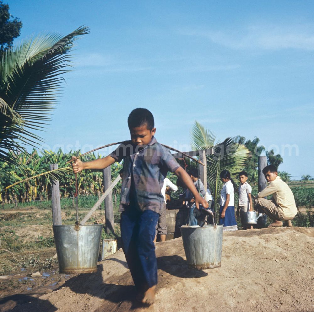GDR image archive: Vientiane - Kinder bewässern die Pflanzen im Schulgarten in einem Dorf in der Demokratischen Volksrepublik Laos.