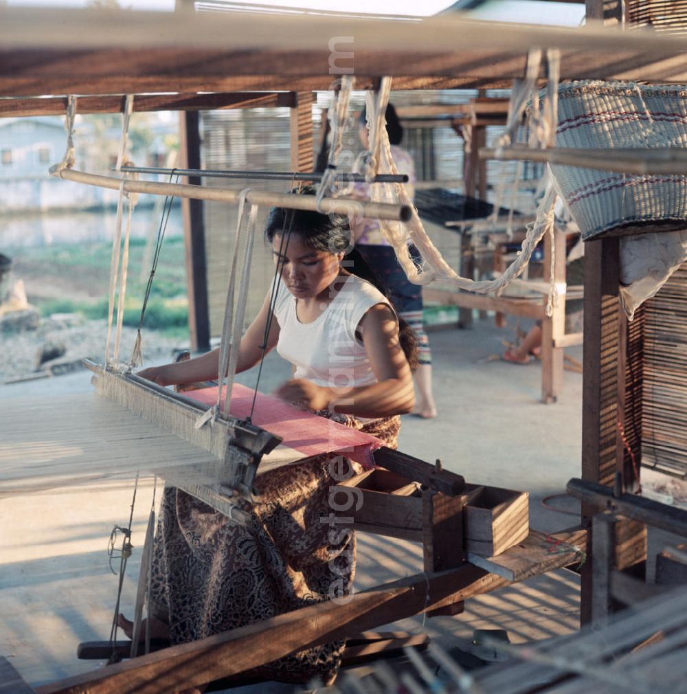 GDR image archive: Vientiane - Eine Frau webt an einem Holzwebstuhl in einer Weberei in Vientiane, der Hauptstadt der Demokratischen Volksrepublik Laos.