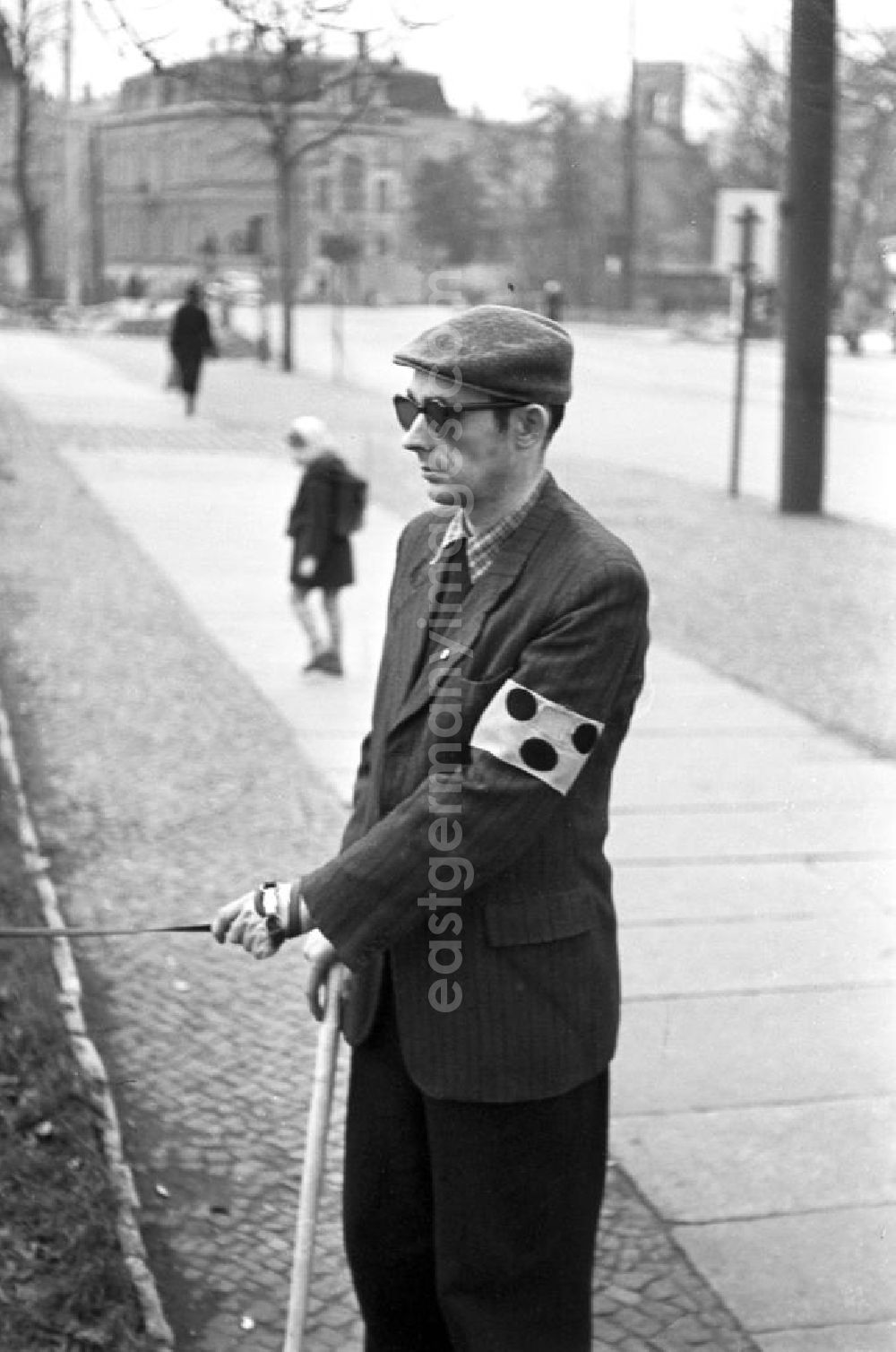 GDR image archive: Leipzig - Ein blinder Mann mit schwarzer Brille und Blindenzeichen geht mit seinem Hund in Leipzig spazieren.