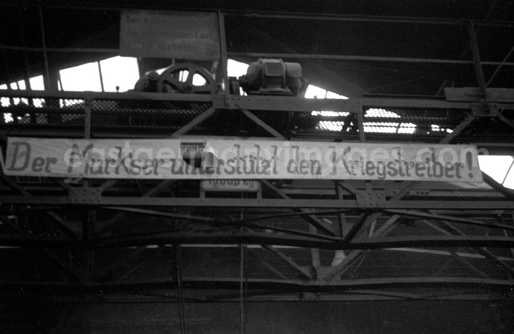 GDR picture archive: Bautzen - The slogan The botcher supports the warmonger! hangs in the workshop of the Association of People’s Owned Locomotive and Wagon Construction Enterprises (VVB LOWA) in Bautzen, Saxony in the territory of the former GDR, German Democratic Republic