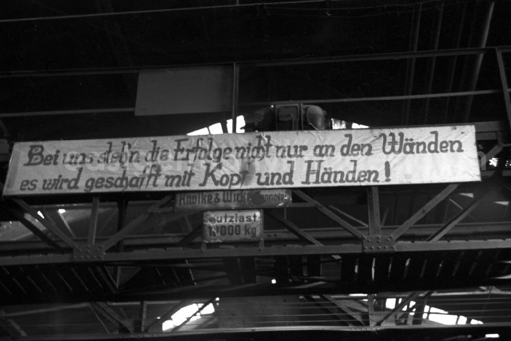 GDR photo archive: Bautzen - The slogan With us, successes are not just written on the walls, we achieve them with our heads and our hands! hangs in the workshop of the Association of People’s Owned Locomotive and Wagon Construction Enterprises (VVB LOWA) in Bautzen, Saxony in the territory of the former GDR, German Democratic Republic