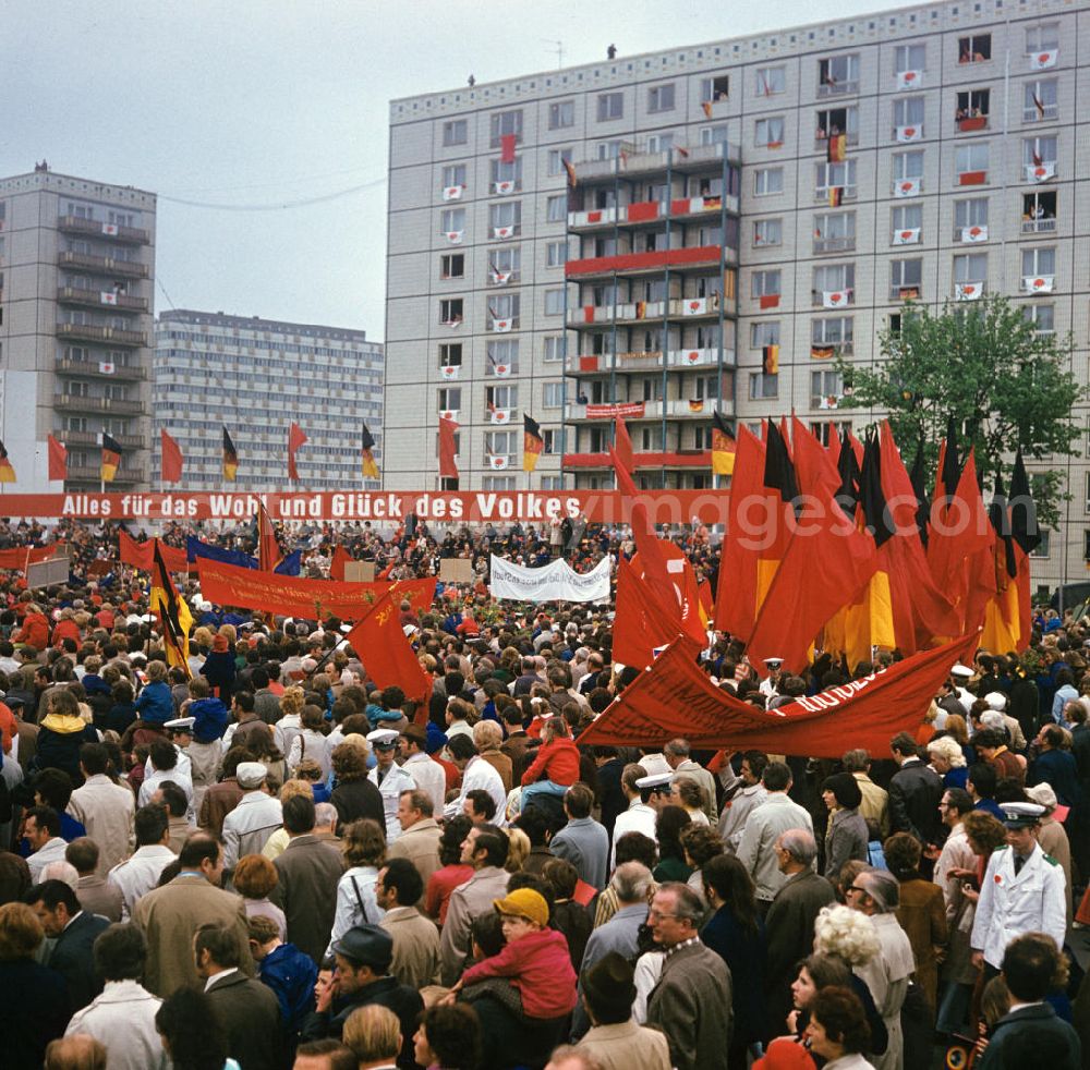 GDR picture archive: Berlin - Fahnen und Transparente werden zur traditionellen Demonstration in der Hauptstadt der DDR am 1. Mai 1974, dem Internationalen Kampf- und Feiertag der Werktätigen für Frieden und Sozialismus, vor der Ehrentribüne mit der Losung Alles für das Wohl und Glück des Volkes in die Höhe gehalten, aufgenommen auf der Berliner Karl-Marx-Allee.