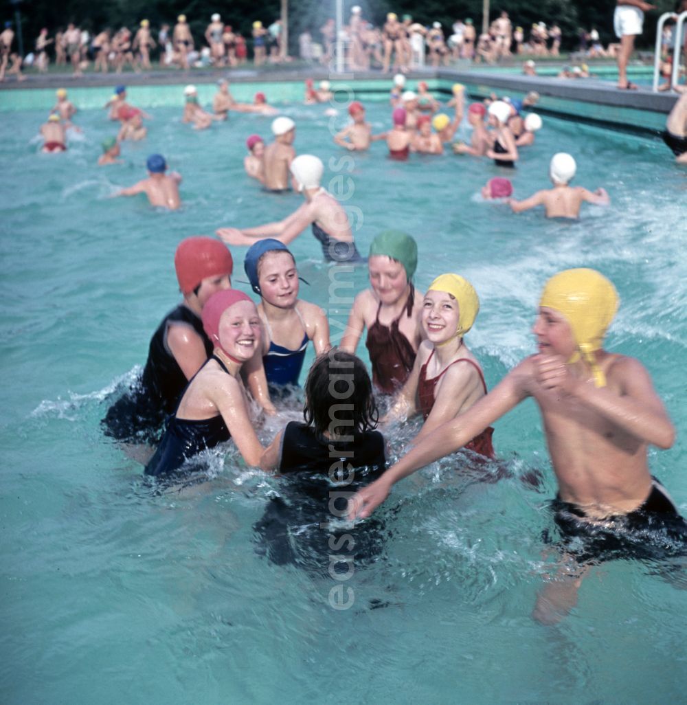 Berlin: Girls in swimsuits, swimming caps and swimming rings in an outdoor swimming pool on Wolfshagener Strasse in the Pankow district of East Berlin in the territory of the former GDR, German Democratic Republic