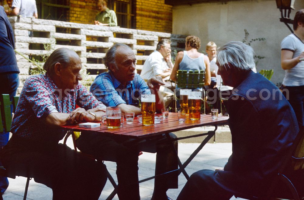 GDR photo archive: Berlin - Men sit in a bar and drink beer in East Berlin on the territory of the former GDR, German Democratic Republic