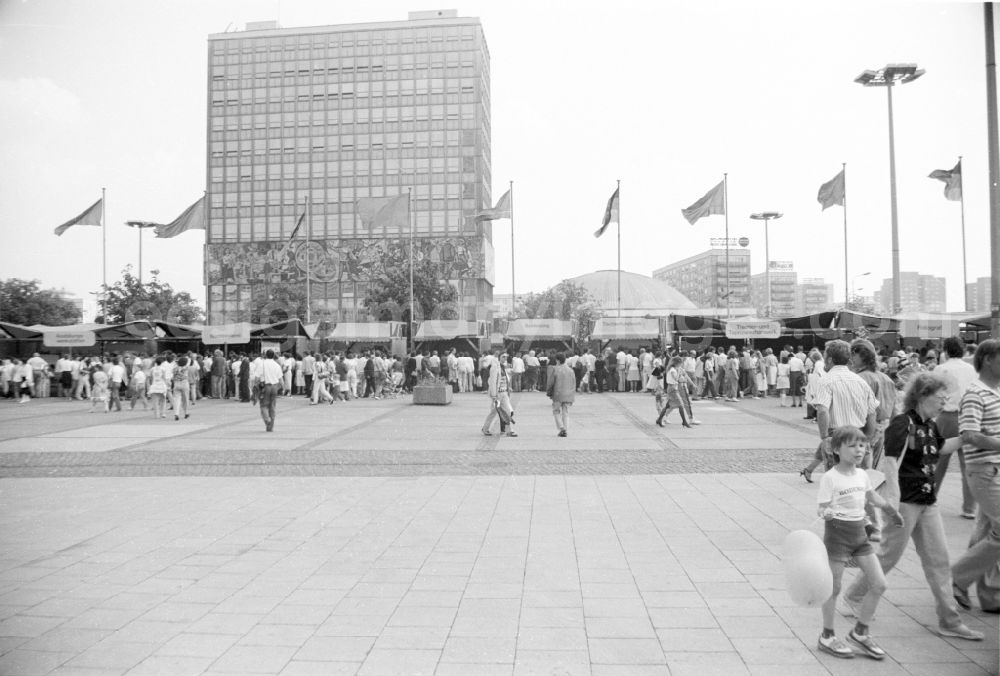 GDR picture archive: Berlin - Festively decorated city on the occasion of the National Youth Festival in Berlin-Mitte on the territory of the former GDR, German Democratic Republic. Various stalls on Alexanderplatz. Flags fly on the poles in front of the Haus des Lehrers HdL and the congress hall