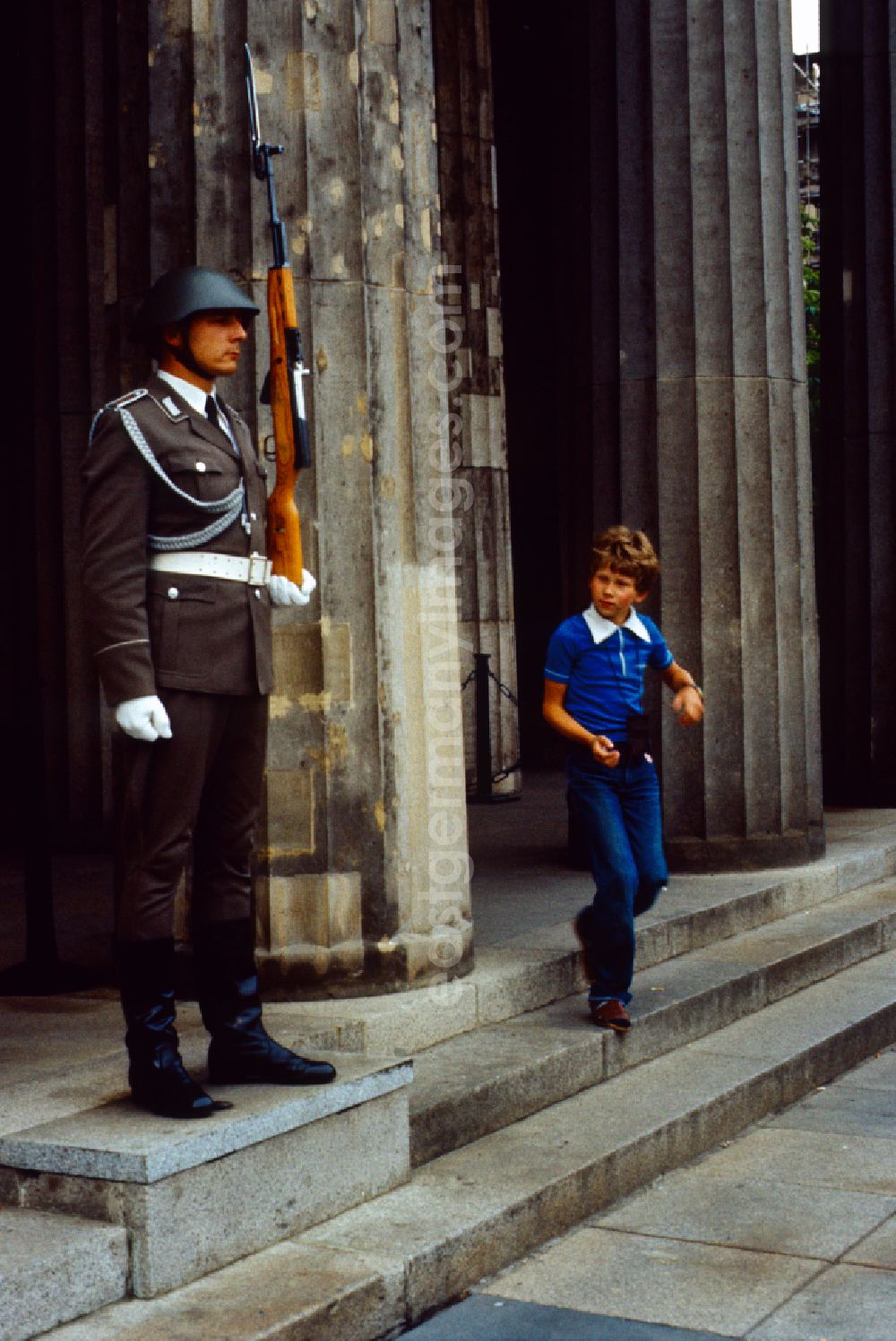 GDR picture archive: Berlin - New Guard on the boulevard Unter den Linden by Karl Friedrich Schinkel in Berlin in the GDR. Boy runs past a soldier of the NVA guard of honour